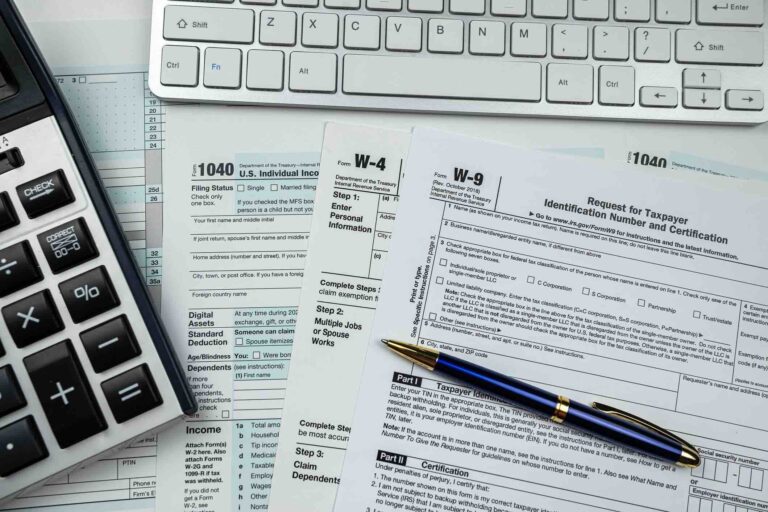 w-9 tax form laid on desk with keyboard, pen, and calculator