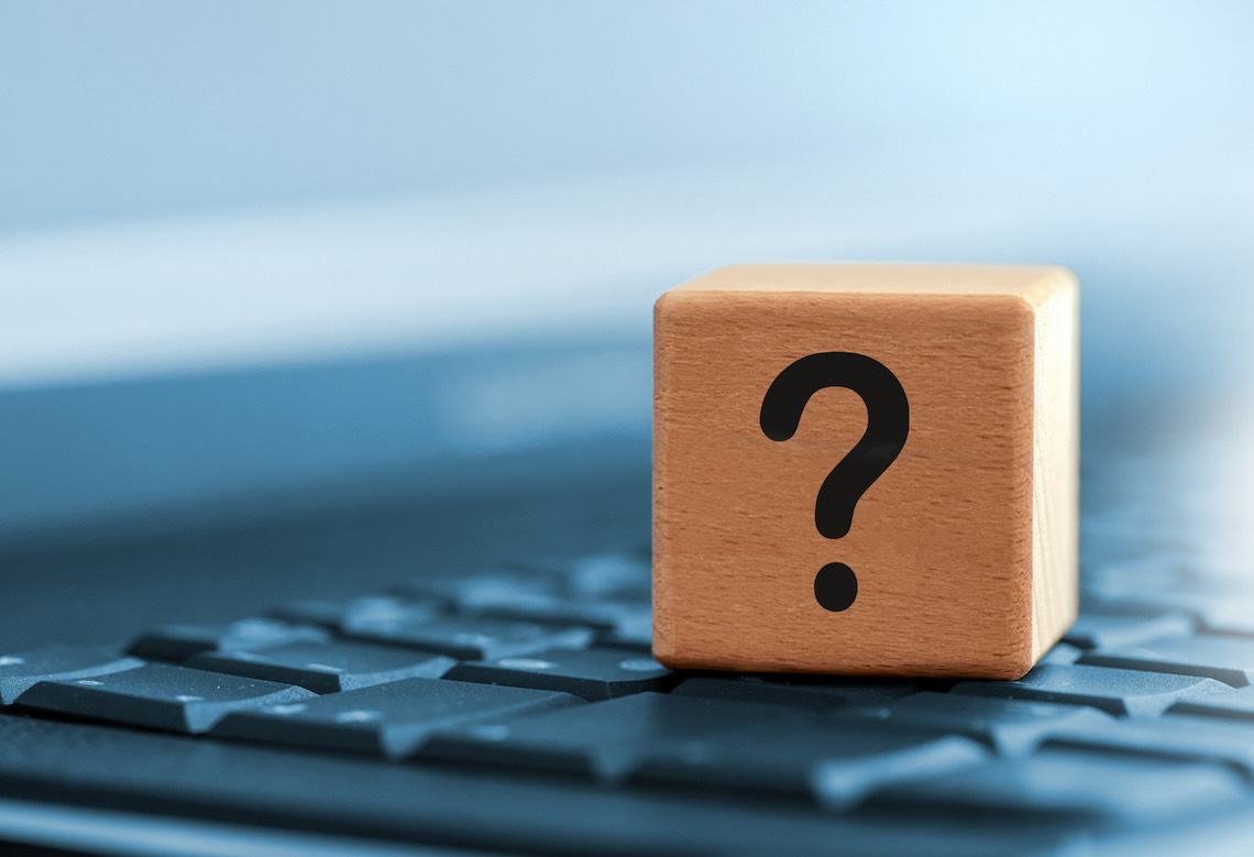 close up of wooden question mark on keyboard